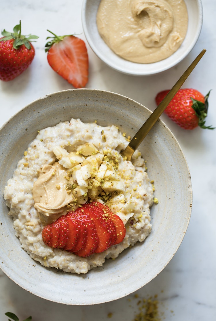Bilde av havregrøt med cashewsmør, og friske jordbær.